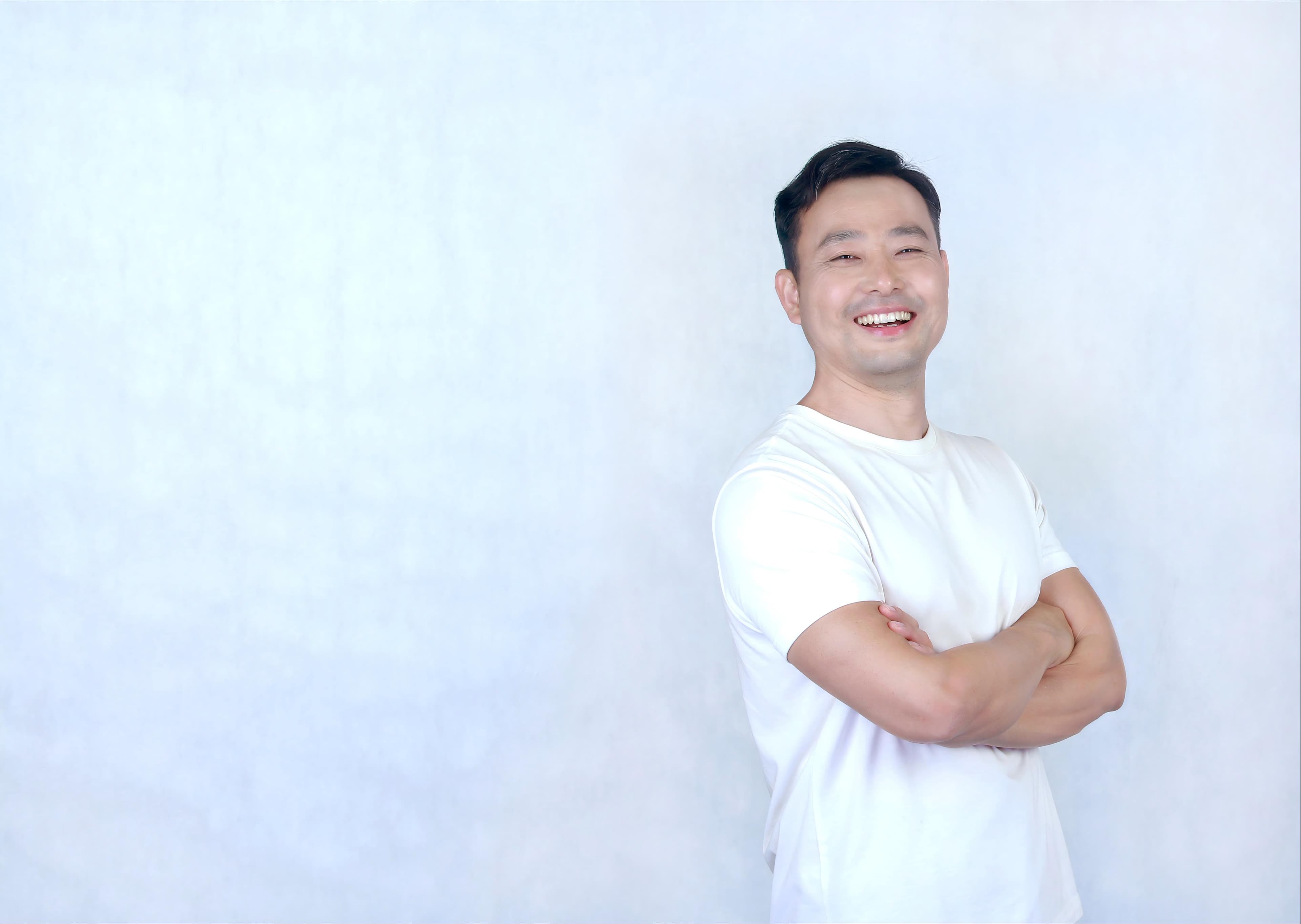 Kai smiling with his arms crossed